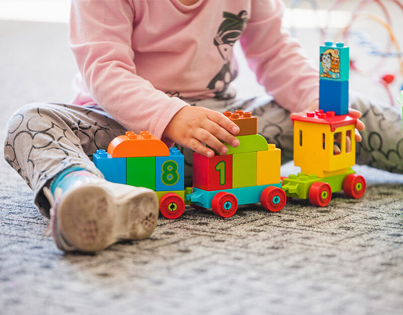 zdjęcie dziecka bawiącego się zabawkową kolejką
